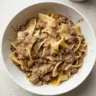 Delicious plate of beef and noodles garnished with herbs