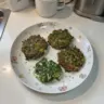 Delicious crispy spinach fritters served on a plate with a dipping sauce.
