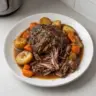 Delicious crockpot pot roast served with vegetables on a plate.