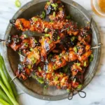 Juicy Honey Garlic Chicken Skewers served on a plate with garnishes.