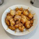 Delicious homemade Honey Sesame Chicken served with sesame seeds and green onions.