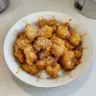 Delicious homemade Honey Sesame Chicken served with sesame seeds and green onions.