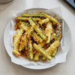 Crispy Parmesan Zucchini Fries served on a plate with dipping sauce