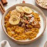Bowl of quick pumpkin oatmeal topped with nuts and spices