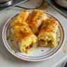 Delicious sausage and egg breakfast rolls served on a plate.