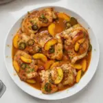 Grilled Jalapeño Peach Chicken garnished with fresh herbs on a plate.