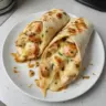 Cheesy garlic chicken wraps served with fresh herbs and topped with melted cheese